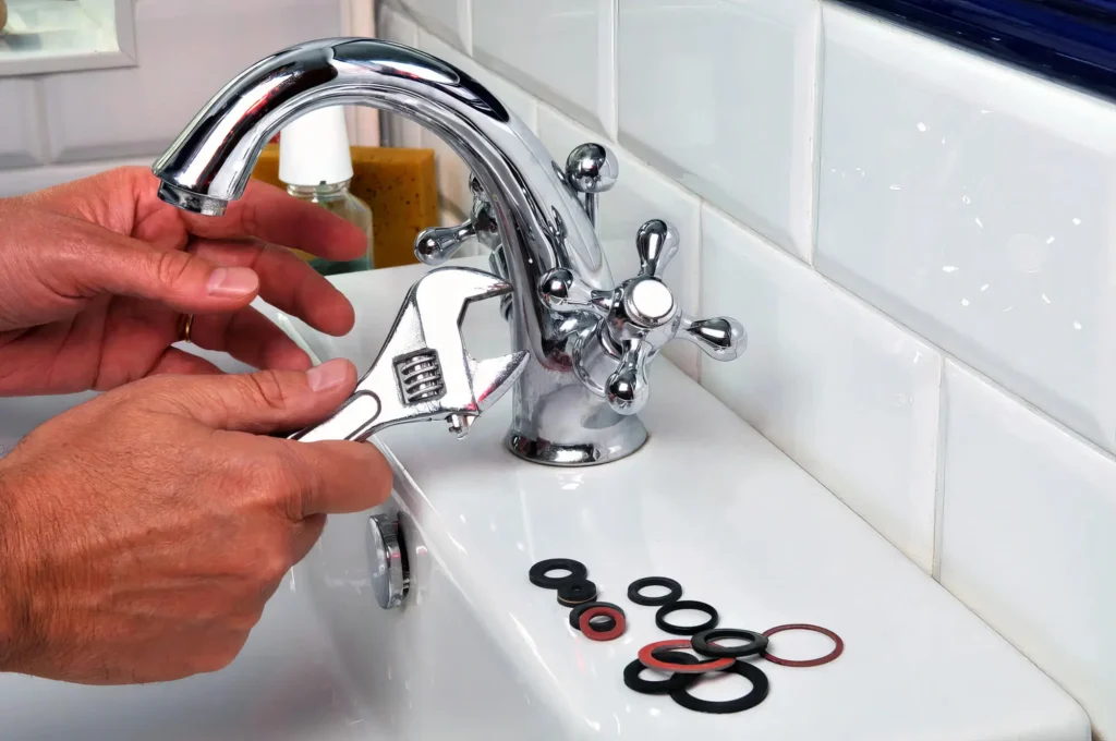 Plumber performing maintenance on a bathroom faucet in DeLand
