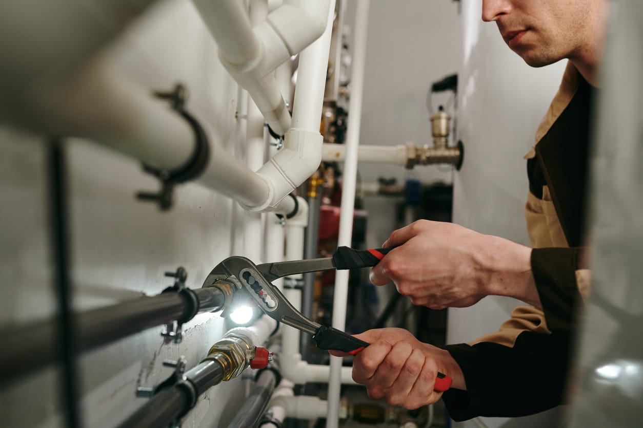 Plumbers maintaining commercial plumbing pipes in DeLand