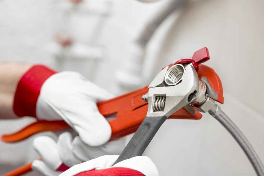Plumber holding pipe wrenches for an emergency repair in DeLand