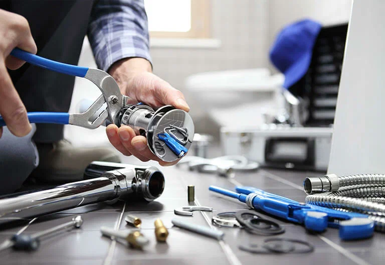 Technician repairing a plumbing fixture with professional tools in DeLand
