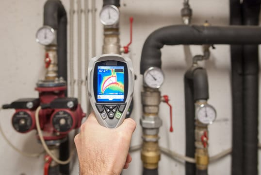 Plumber using a thermal imaging camera to inspect pipes in DeLand