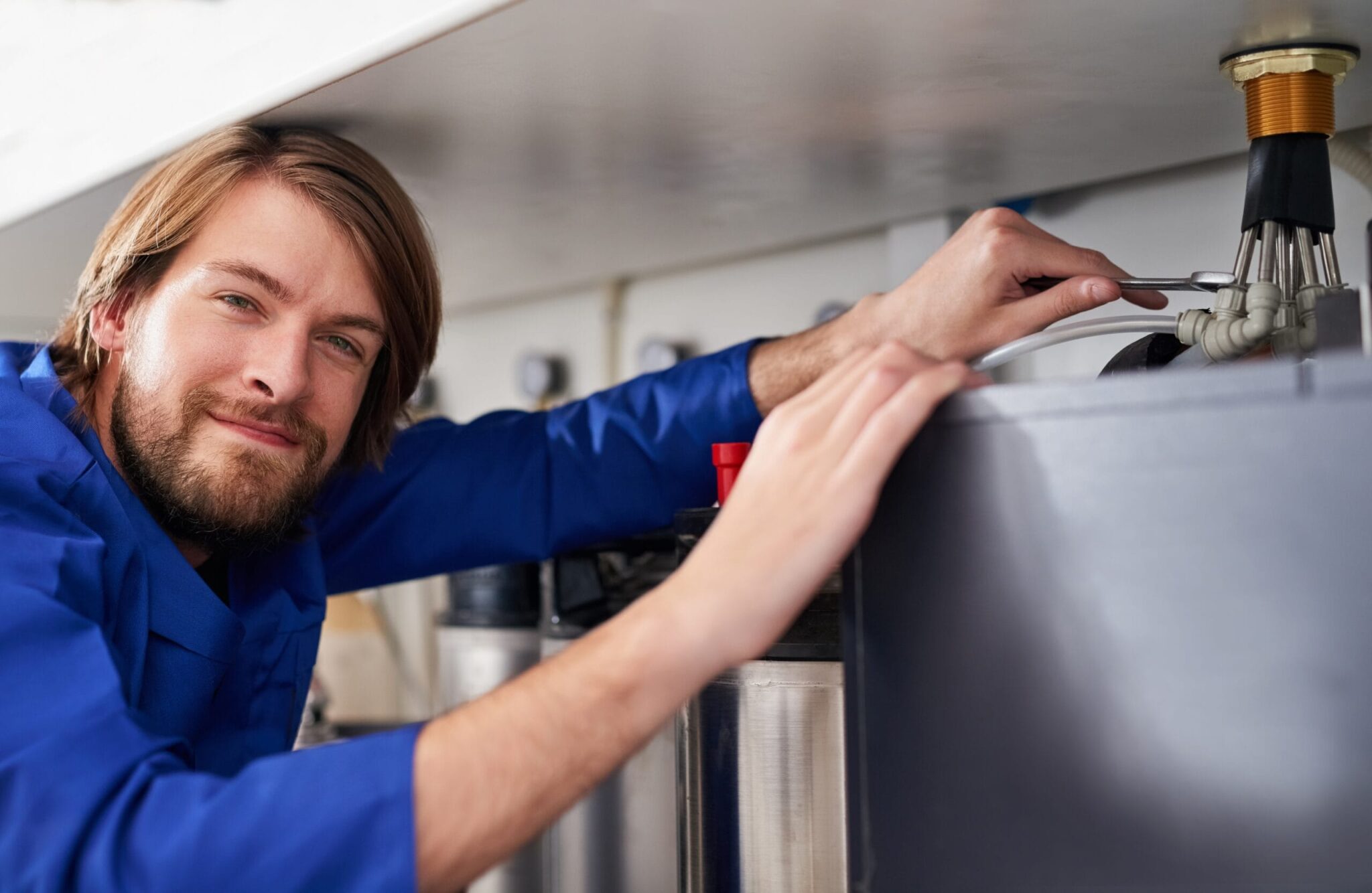 Technician servicing a residential water heater tank in DeLand